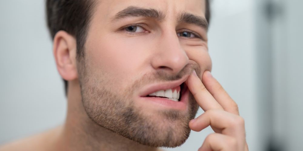 Patient examining gums before laser gum treatment at North Star Dentistry in Mississauga for periodontal therapy and gum reshaping