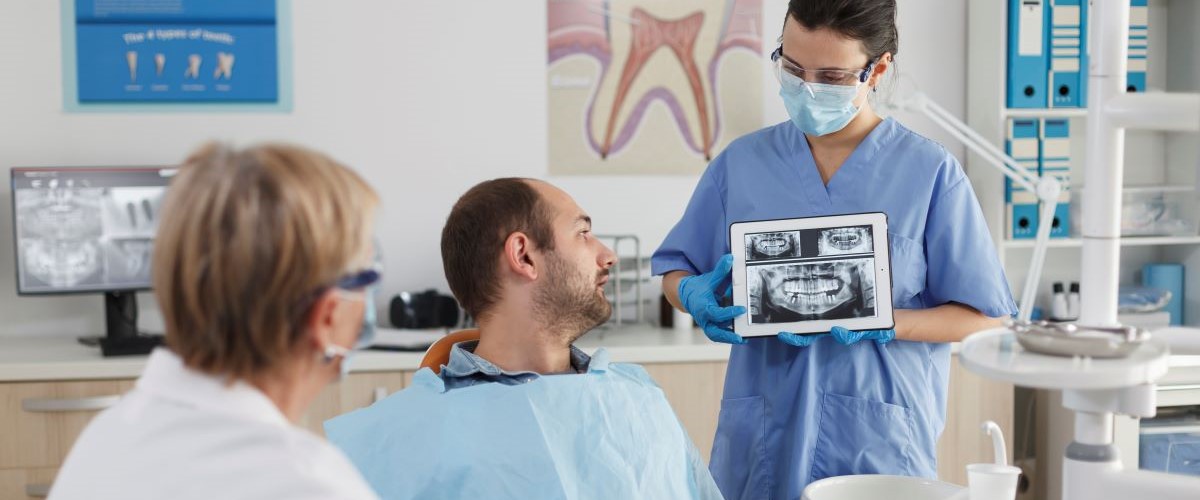 Oral cancer screening examination at North Star Dentistry in Mississauga — dentist reviewing intraoral X-ray results with patient during preventive checkup