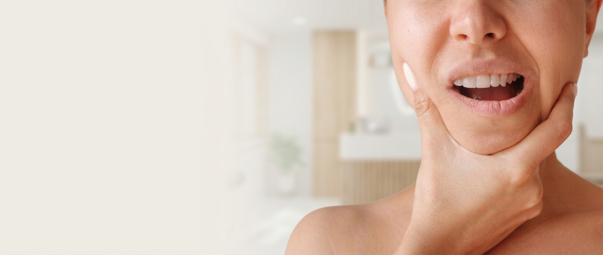 Woman experiencing TMJ jaw pain holding her face – TMJ treatment and facial pain relief at North Star Dentistry in Mississauga, Ontario